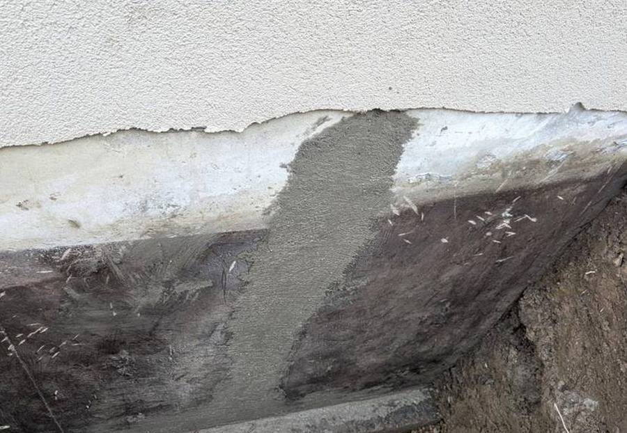 After: the same style of foundation wall repaired, sealed and freshly parged