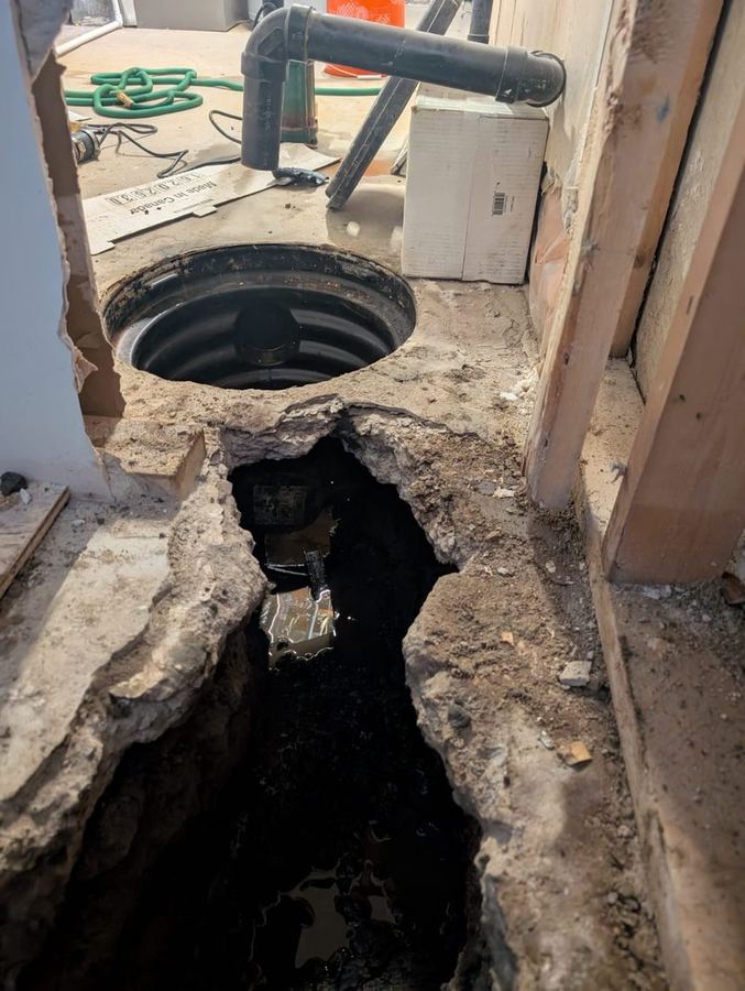 Interior basement drainage trench and new sump pit opened in a concrete floor