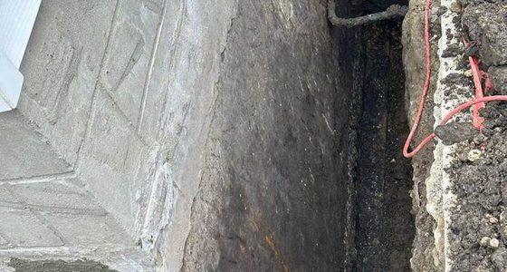 Excavated foundation corner repaired and parged